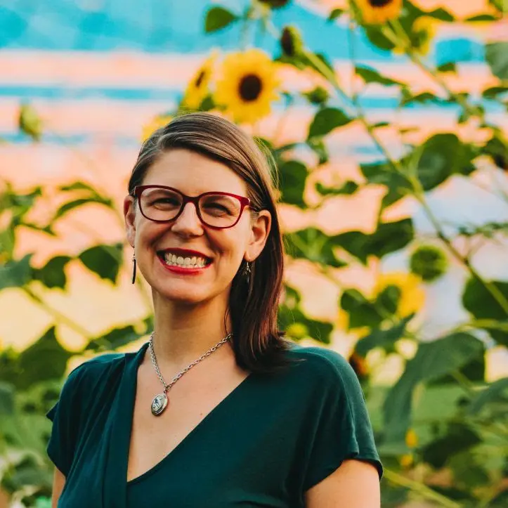 The Rev. Celeste Kennel-Shank smiling among sunflowers
